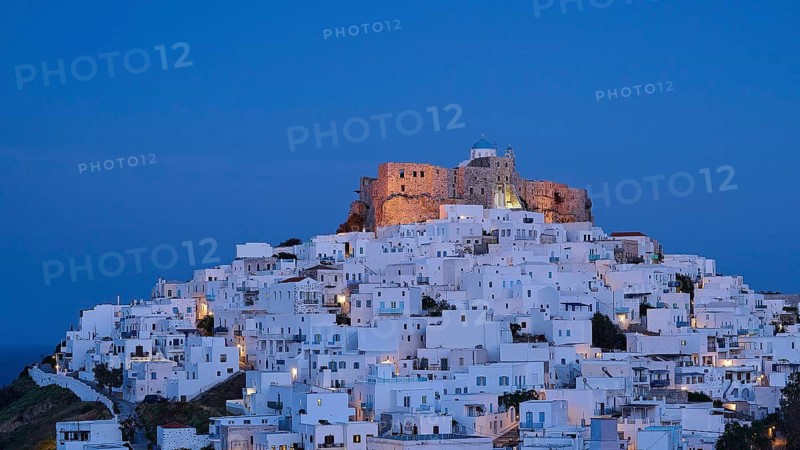An illuminated castle above a white town at night, Querini Castle, Chora, Astypalea, Dodecanese, Greek Islands, Greece