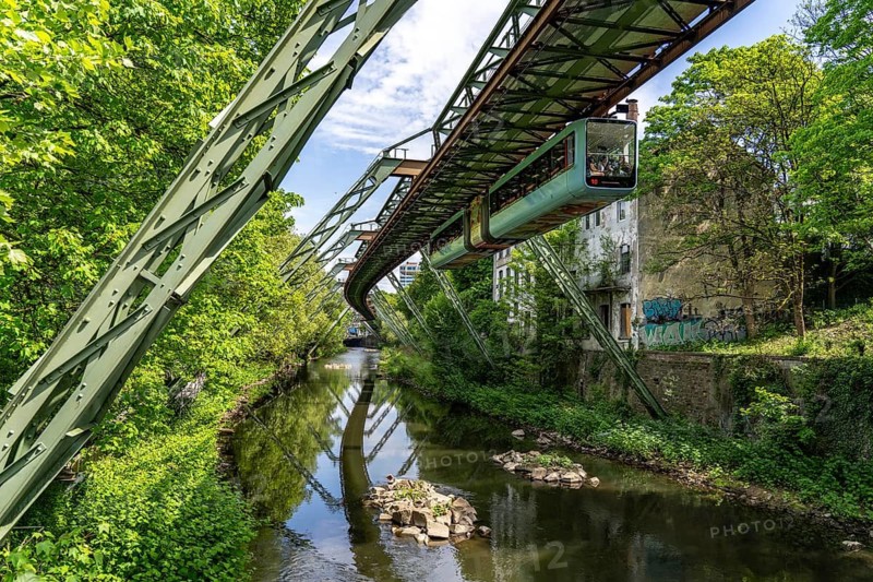 The Wuppertal suspension railway, train of the latest generation 15, floats above the Wupper, North Rhine-Westphalia, Germany