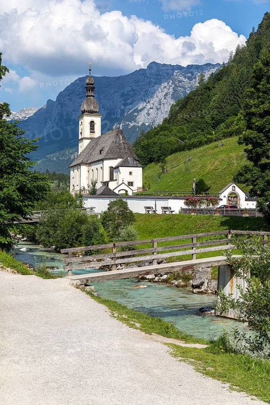 Famous view of the parish church of St. Sebastian with bridge over the Ramsauer Ache in the Ramsauer Malerwinkel with horse-rider Alm and Wagendrischelhorn, Ramsau near Berchtesgaden, Berchtesgadener Land, Bavaria, Germany