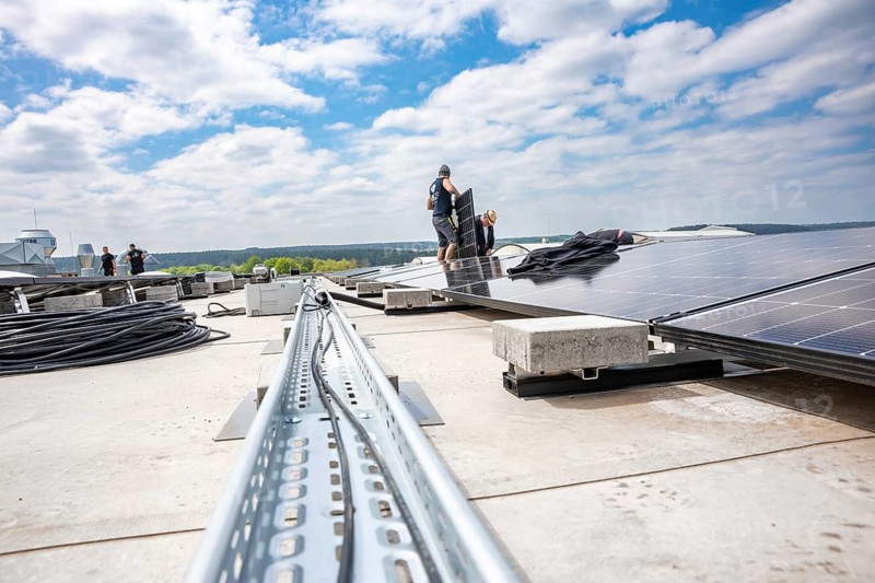 Workers install solar panels on a roof to see sky and distance, PV Assembly, Perrot company, Calw, Germany