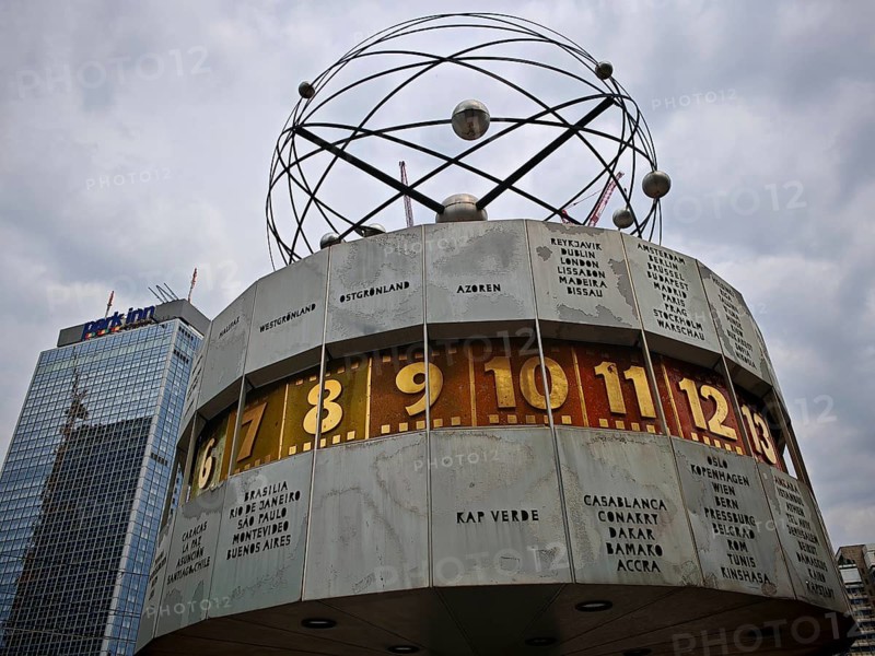 The world clock on Alexanderplatz shows different time zones under cloudy skies, Alexanderplatz, Berlin