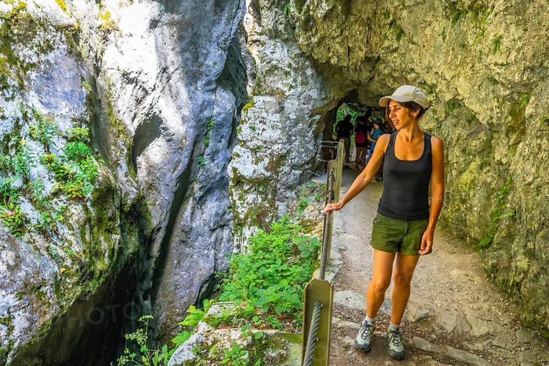 Female tourist exploring tolmin gorge in triglav national park, enjoying breathtaking rock formations and lush greenery