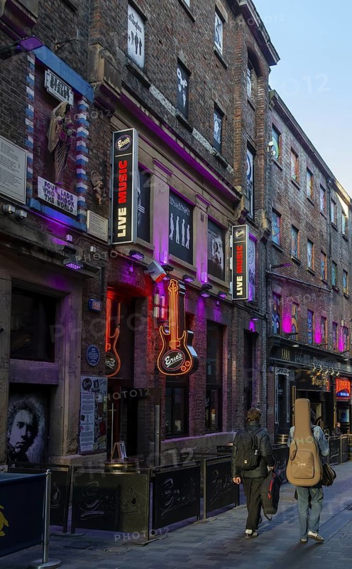 Men walking past with guitars, Eric's music club, Mathew Street, Liverpool, Merseyside, England, UK