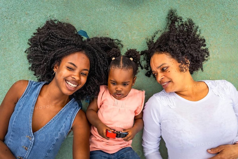 Top view of african happy multi-generational family lying on the ground of a park