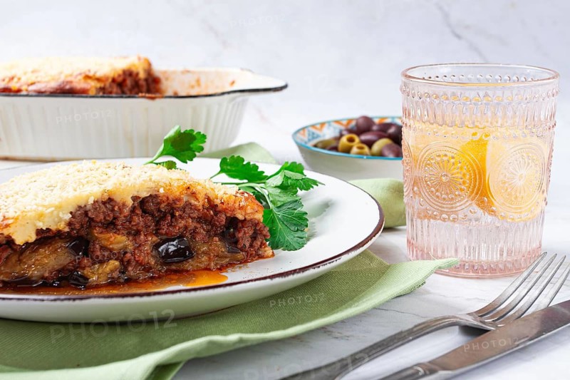 Moussaka served with olives, in a bright kitchen setting, homemade, no people