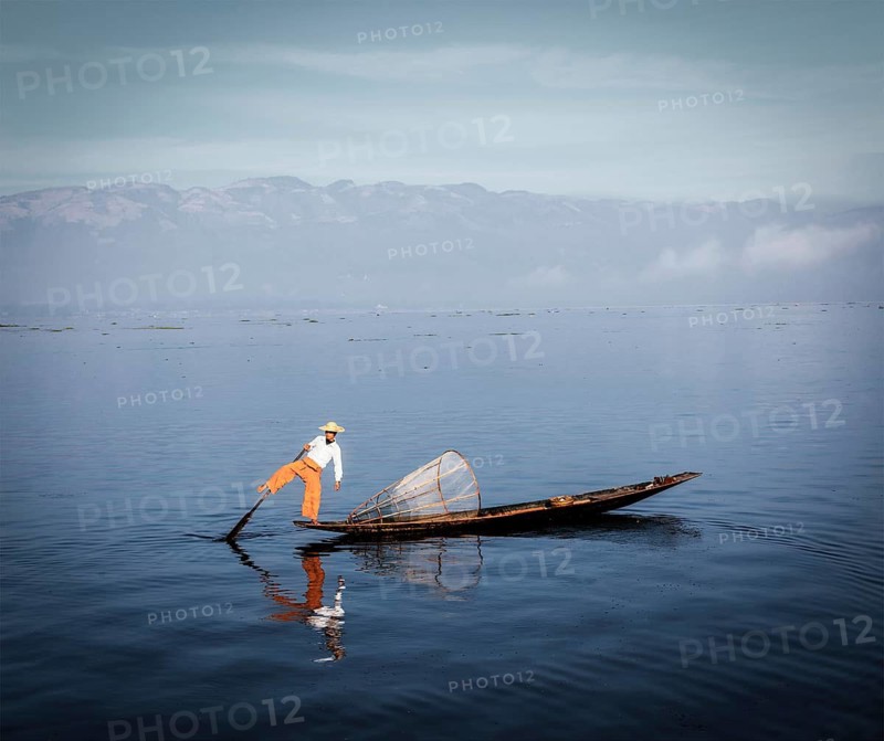 Myanmar travel tourist sighseeing attraction, Traditional Burmese fisherman rowing on one leg at Inle lake, Myanmar famous for their distinctive one legged rowing style. Vintage filtered retro effect hipster style image