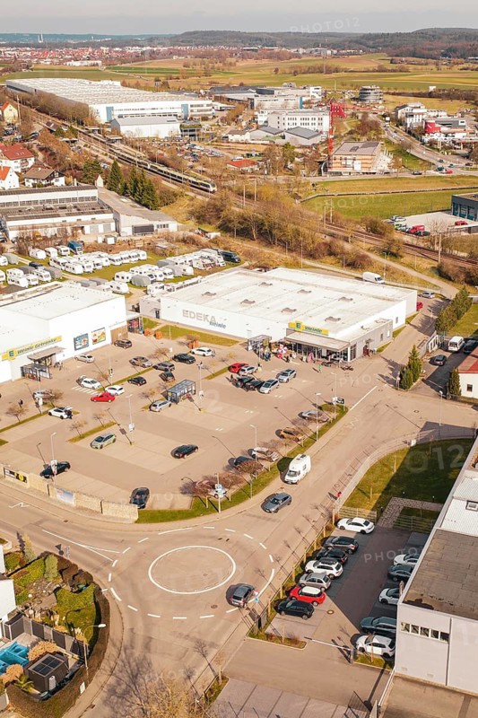 Aerial view of a shopping mall with lots of cars in the parking lot in an urban industrial area, Gärtringen, Böblingen district, Germany