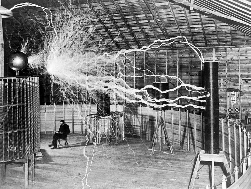 Nikola Tesla sits next to his amplifier transmitter, which could generate millions of volts. Multi-exposure photo, December 1899, Colorado Springs, USA Nikola Tesla (10 July 1856 in Smiljan - 7 January 1943 in New York City) was one of the great inventors of the 19th and 20th centuries. His inventions in the field of electrical engineering in particular were and still are of great importance today. The two-phase alternating current system he developed still determines the way we transmit electrical energy today. In the so-called 'electricity war' of 1890, George Westinghouse, who favoured Tesla's system, prevailed over Thomas Edison's system. Since then, Tesla's technology has determined the development of power grids in the USA and later worldwide. On 20 March 1900, Tesla received his first patent for wireless energy transmission, which is now regarded as the first patent for radio technology. In his honour, the Nikola Tesla Museum is now located in Belgrade, where many of his inventi...