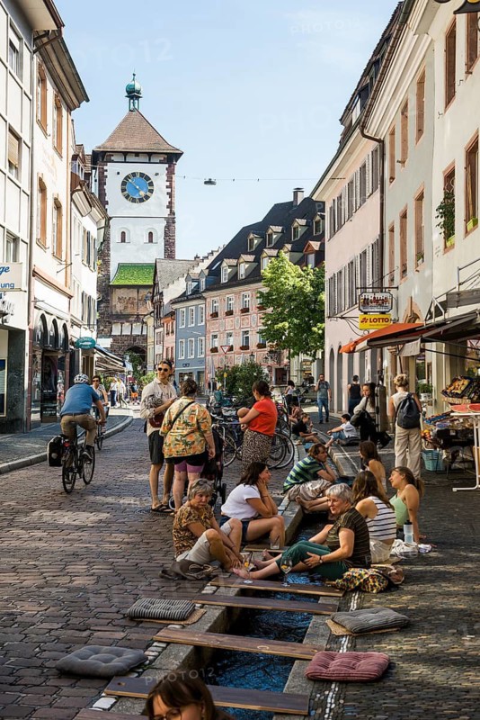 People sitting by and in the stream, Bächle, bathing in the city, heat, heat wave, climate change, Dreisam, Freiburg im Breisgau, Black Forest, Baden-Württemberg, southern Germany, Germany