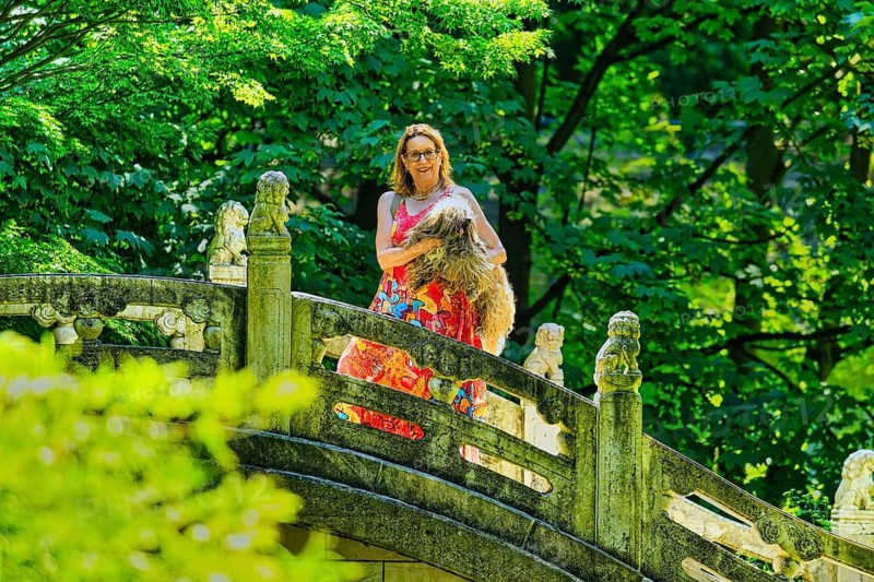 Woman with dog standing on a bridge, Chinese Garden at Duisburg Zoo, Duisburg, North Rhine-Westphalia, Germany