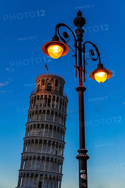 The Leaning Tower under an illuminated street lamp in the evening light, Pisa, Tuscany, Italy