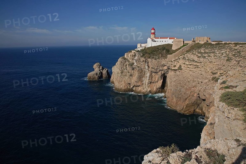 The lighthouse right on Cabo de Sao Vicente in the Algarve at the southwesternmost point of mainland Europe, Portugal, A lighthouse on a cliff overlooking the vast sea under a clear blue sky