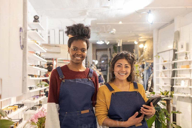 A vibrant sunglasses store showcases its friendly staff ready to assist customers. The bright interior displays a wide selection of fashionable eyewear and accessories for all ages