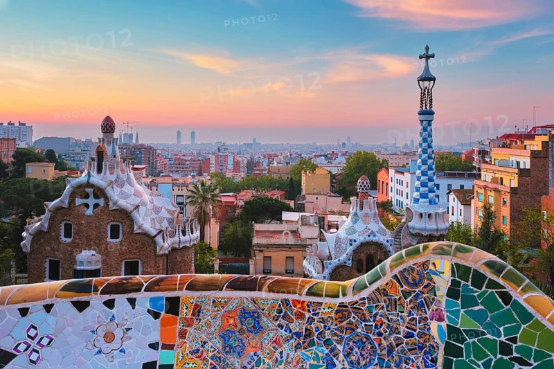 Barcelona city view from Guell Park with colorful mosaic buildings in tourist attraction Park Guell in the morning on sunrise. Barcelona, Spain