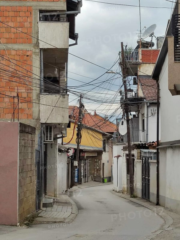 Chaotic installation of power and telecommunications cables on a utility pole, Prizren, Kosovo, Balkans