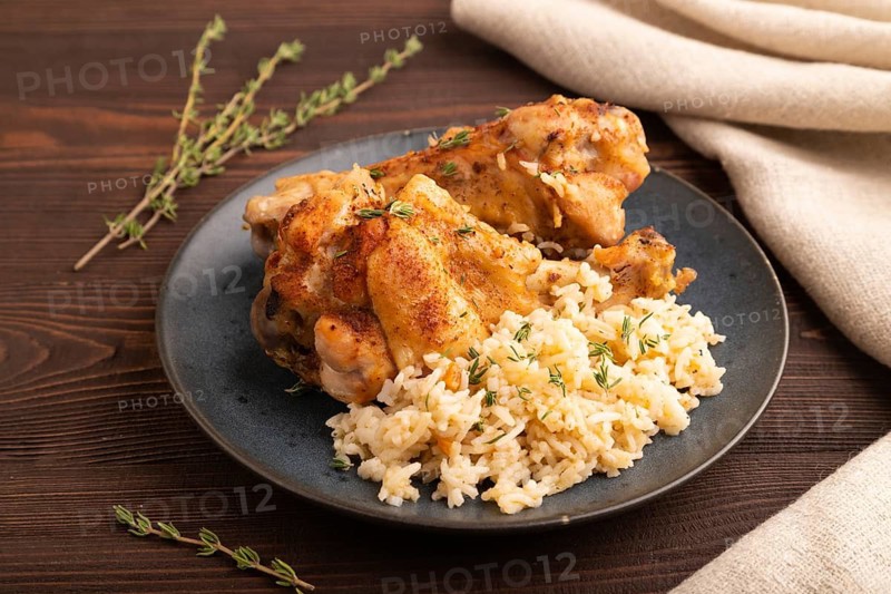 Fried Turkey Wing with spices and thyme on plate on brown wooden background and linen textile. side view, close up