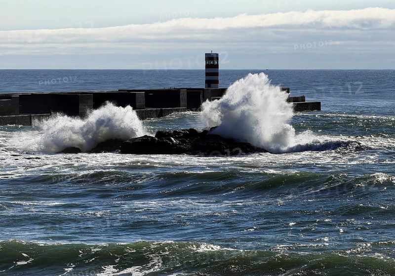 Ocean surf on the Atlantic coast with the Farolim da Barra do Douro lighthouse, Porto, Portugal