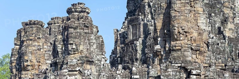 Panoramic image of giant stone-carved faces of the Bodhisattva Lokeshvara, also known as Avalokiteshvara, Bayon Temple, Angkor Thom, UNESCO World Heritage Site, Angkor Wat, Siem Reap, Cambodia
