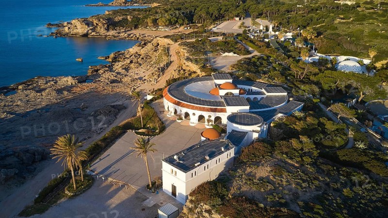 Drone shot, morning light, A round building on the rocky Mediterranean coast, surrounded by pine trees, overlooking the blue sea at sunset, Kalithea, Kallithea, thermal baths, spa, Rhodes, Dodecanese, Greek Islands, Greece