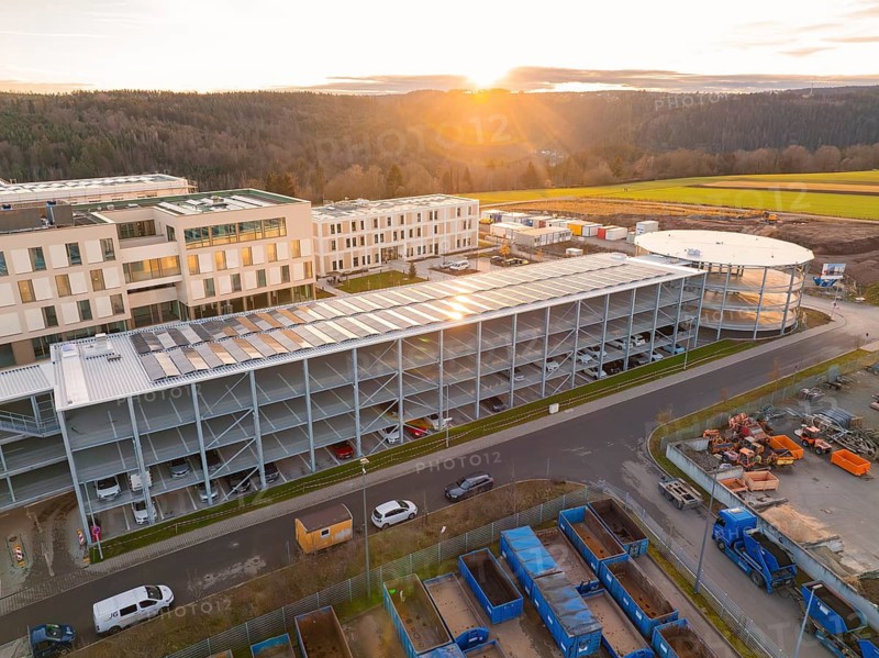 Industrial complex with multi-storey car park and modern buildings, at sunset, in a rural setting, new Calw health campus, Calw district, Black Forest, Germany
