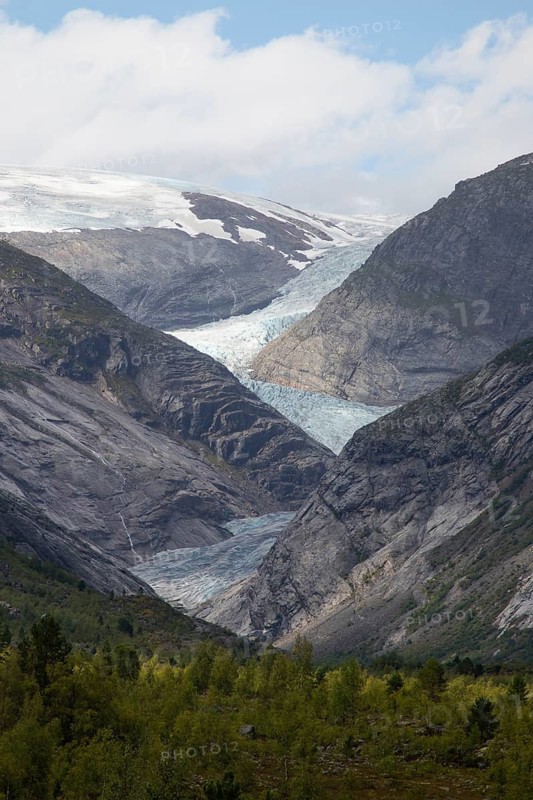 A stunning view of the Nigardsbreen Glacier descending between steep rocky mountains in Norway
