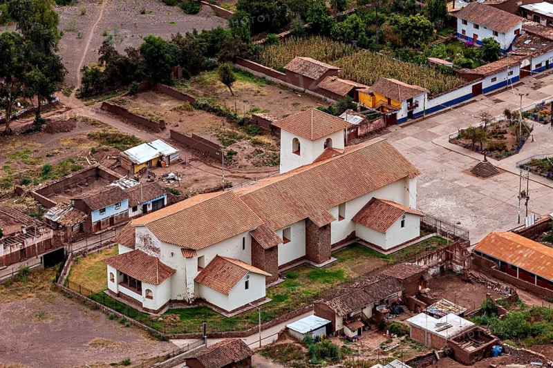 Aerial view of a traditional church with red roofs in a small village in Peru surrounded by greenery, The town of Ollantaytambo in the Andes of Peru