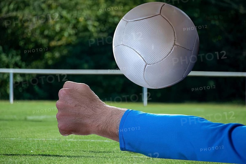 (Photomontage) Fistball symbol image: close-up of a fistball player on the ball