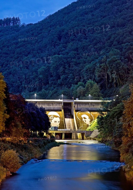 The dammed river Our with art on the illuminated dam wall of the lower reservoir in the evening, Vianden, Our National Park, Luxembourg