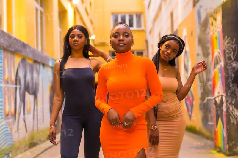 San Sebastián, Gipuzkoa Spain, February 2021: Fashionable urban style with three black African girls on a city street, tight dresses and seductive looks. Lifestyle girls of color