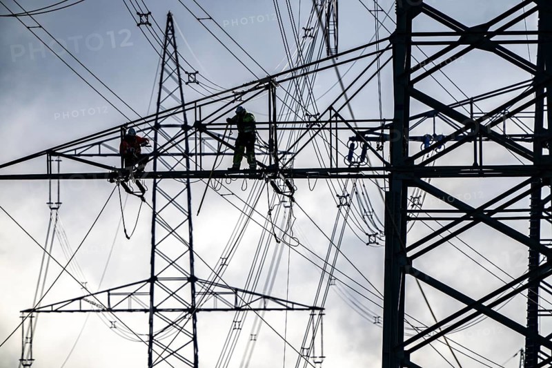 Work on a 380 kV high-voltage overhead line, new construction, along the A57 motorway, near Meerbusch, workers on the boom of the high-voltage pylon, North Rhine-Westphalia, Germany