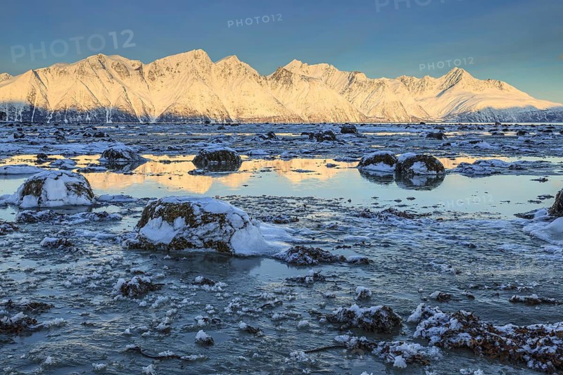 Morning light over snow-covered mountains, fjord, low tide, winter, Lyngen Alps, Norway