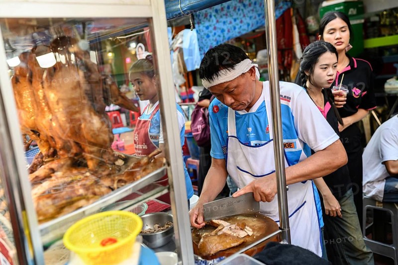 Bangkok, Thailand. February 18th 2025. A local poultry butcher preparing street food at stall in market in Yaowarat Road, Chinatown, Bangkok, Thailand