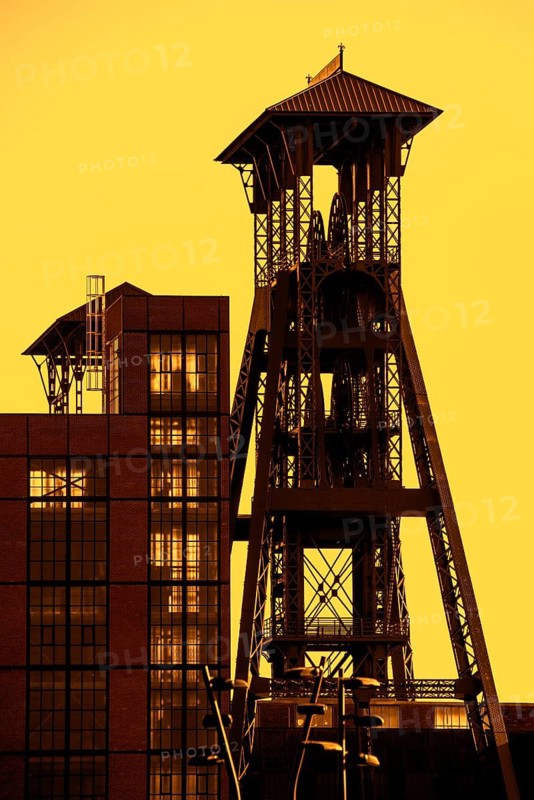 Colliery headframe, hoist frame and coal mine building in the coal mining town Beringen at sunset, Koersel, province of Limburg, Flanders, Belgium