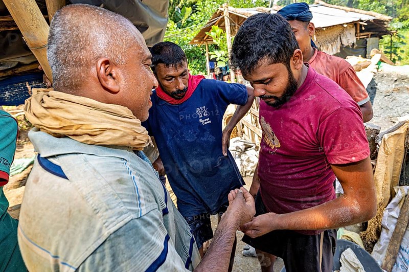 Group of men talking in a rural work environment, the sapphire and gemstone mines at Ratnapura in Sri Lanka