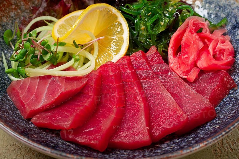 Tuna sashimi with daikon and wakame salad, pickled ginger, in a bowl