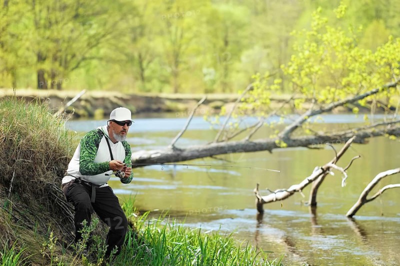 Fisherman trying to do a perfect cast, throwing lure. Spining fishing, angling, catching fish. Hobby and vacation. Photo with shallow depth of field taken at wide open aperture