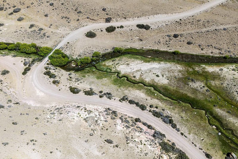 Gravel road ruta 41, Los Antiguos - Paso Roballo, stretch of green along river Columna, aerial view, Argentina