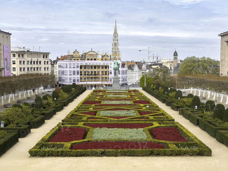 Geometric garden at Mont des Arts with a view of the statue of Albert I and the town hall tower in the background, Brussels, Belgium