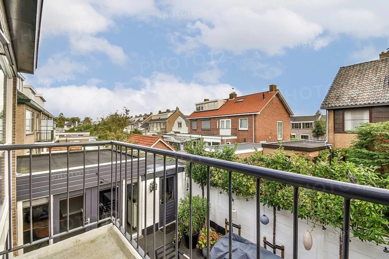 A picturesque urban rooftop view showcasing a blend of modern and classic architecture with greenery accentuating the scene