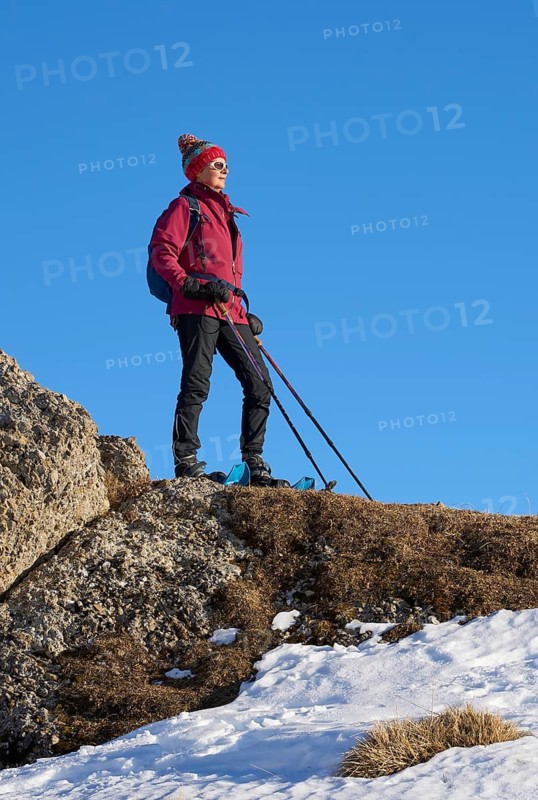 Nice and active senior woman snowshoeing in in the Allgau alps above Immenstadt, Bavaria, Germany