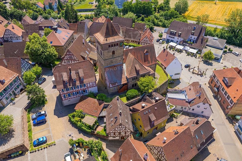 Aerial view of a village with half-timbered houses and a central tower surrounded by green trees, Ötisheim, Enzkreis, Germany