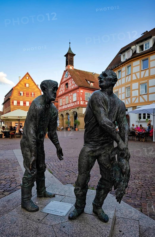 Bronze figures, sculptures The Pigeon Houses by Henning Seemann, half-timbered houses behind them, restaurants in front of historic town hall, market square, evening atmosphere, Waiblingen, Baden-Württemberg, Germany