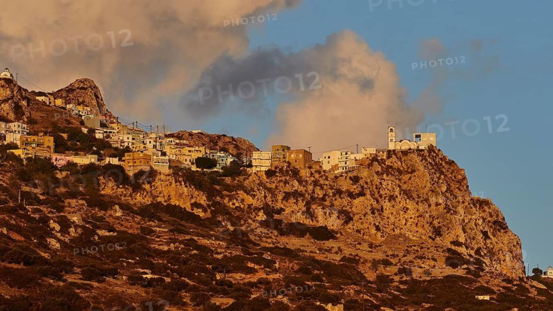 A village on a rocky cliff in the warm morning light with impressive clouds, mountain village Menetes, morning light, Karpathos, Dodecanese, Greek Islands, Greece