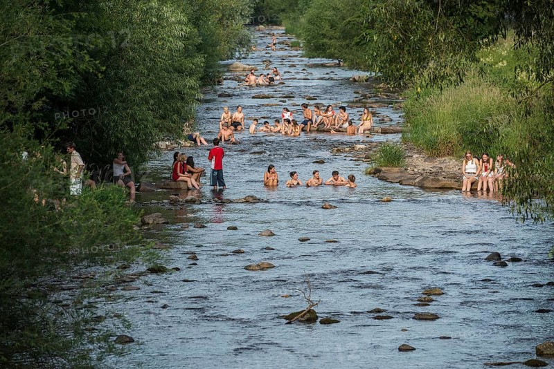 Young people sitting by and in the river, bathing in the city, heat, heat wave, climate change, Dreisam, Freiburg im Breisgau, Black Forest, Baden-Württemberg, southern Germany, Germany