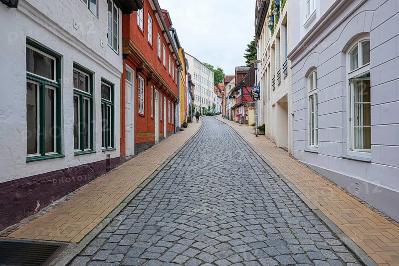 Empty cobbled street lined with colourful old town houses, Flensburg, Germany