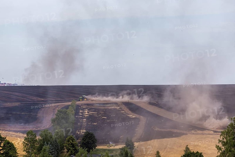 A grain field near Obernauendorf caught fire due to persistent dryness and gusty winds, the local fire brigades, together with farmers and their equipment, fought a further spread, Obernauendorf, Saxony, Germany