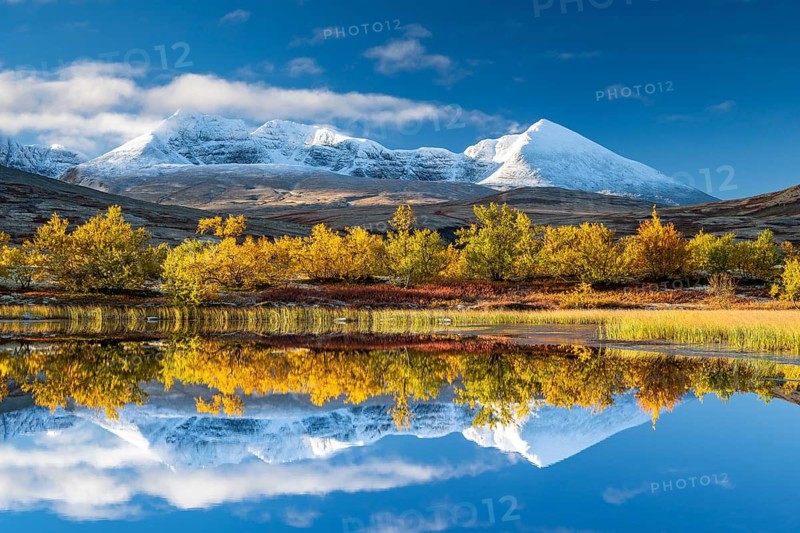 Reflection of the autumn landscape in Rondane National Park, snow-capped mountains, Døråldalen, Norway