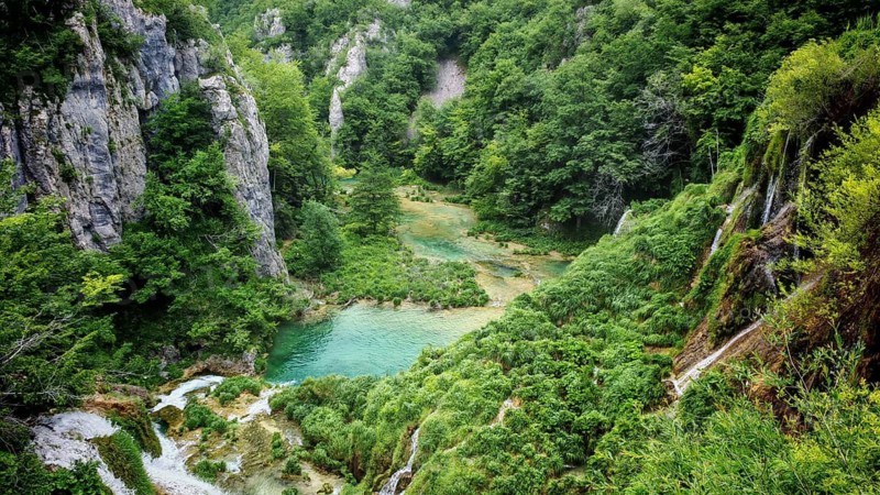 Green gorge with small lake and surrounding rock formations, Plitvice Lakes National Park, Croatia