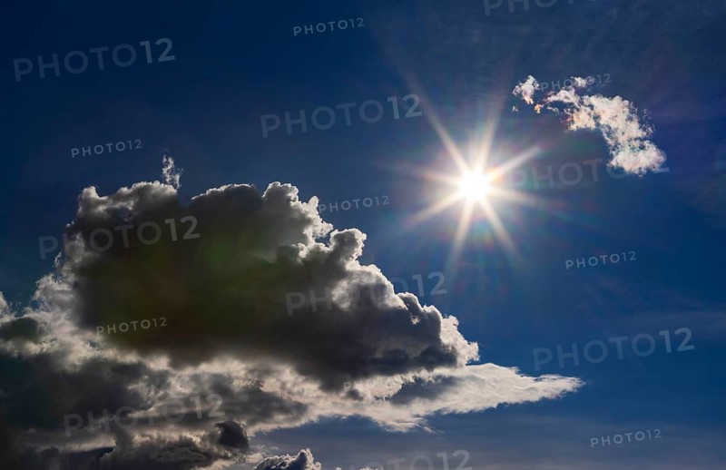 Sun shines between cumulus clouds, dramatic cloudy sky, Austria