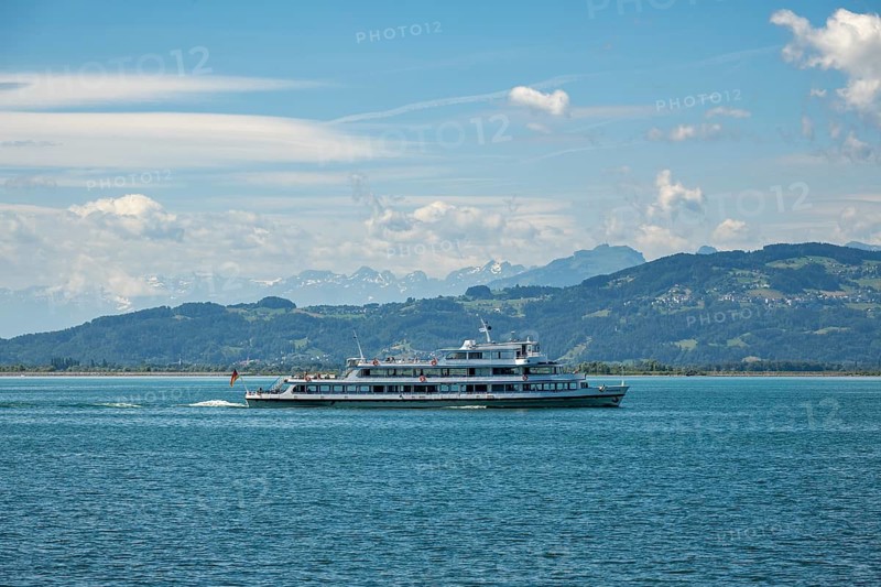 Large passenger ship, excursion ship, MS Münschen der Weißen Flotte sails on the blue Lake Constance against the picturesque backdrop of the snow-covered Alps on a sunny summer day, Lindau, Swabia, Bavaria, Germany